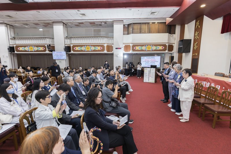 宣言發布現場，台上數人手持紙張朗讀，投影幕顯示心理健康城市共同宣言，台下與會者就座