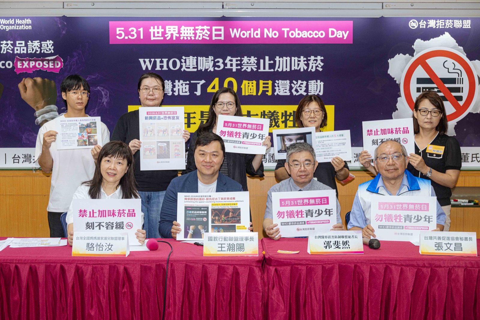 台灣拒菸聯盟 6 個民間團體於台大校友會館世界無菸日記者會合影：林清麗（董氏基金會菸害防制中心主任）、駱怡汝（台灣全國媽媽護家護兒聯盟理事）、王瀚陽（國教行動聯盟理事長）、郭斐然（台灣醫界菸害防制聯盟秘書長）、張文昌（台灣共善促進協會秘書長）、林珊如（全國家長會長聯盟副理事長），舉牌訴求「禁止加味菸品　刻不容緩」「勿犧牲青少年」